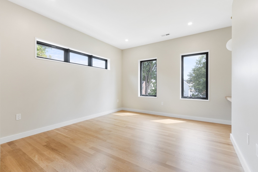 22 Appleton Street, Unit 1 Waltham, MA 02453 - Photo 27 of 36 a view of an empty room with window and wooden floor