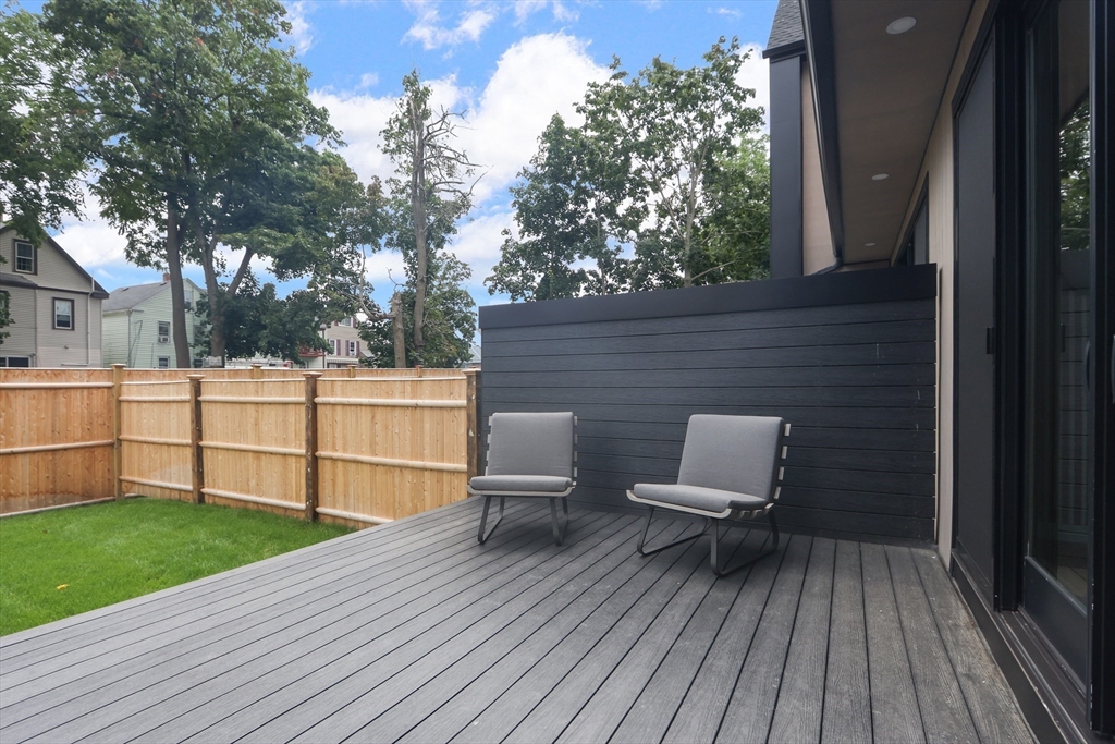22 Appleton Street, Unit 1 Waltham, MA 02453 - Photo 31 of 36 a view of a deck with table and chairs and wooden floor