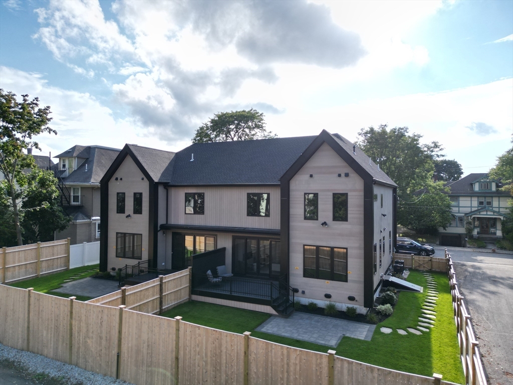 22 Appleton Street, Unit 1 Waltham, MA 02453 - Photo 35 of 36 a view of a house with wooden fence next to a yard