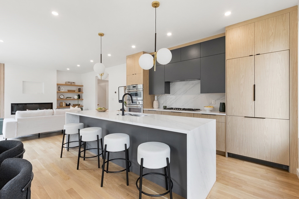 22 Appleton Street, Unit 1 Waltham, MA 02453 - Photo 7 of 36 a kitchen with a refrigerator a dining table and chairs with wooden floor
