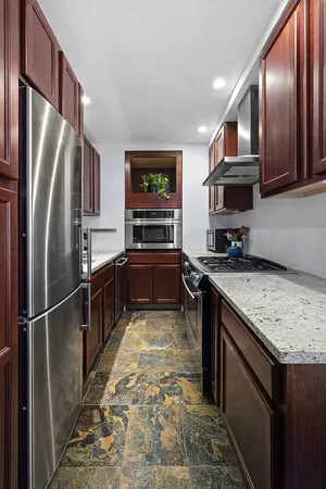 a kitchen with stainless steel appliances granite countertop a refrigerator a stove a sink and a microwave