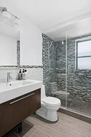 a bathroom with a toilet a sink and mirror