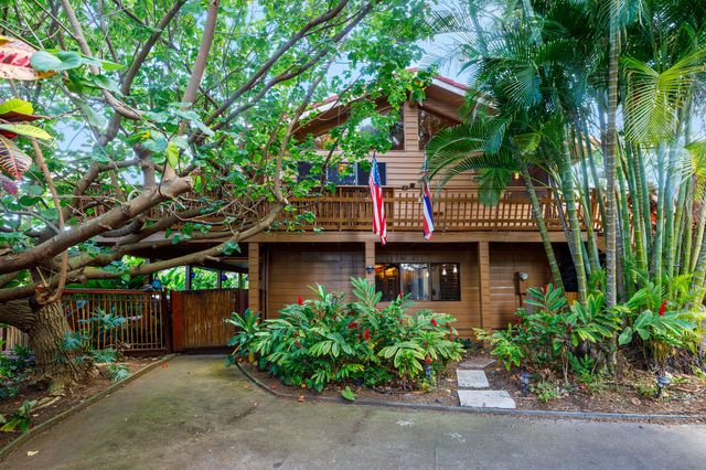 a view of a house with a tree and plants