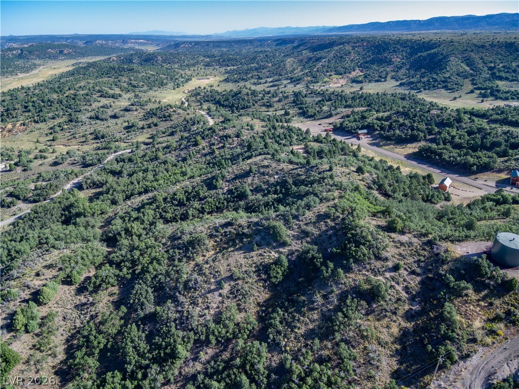 495 West Lutherwood Road Alton, UT 84710 - Photo 12 of 35 A winding road navigates through a verdant, hilly landscape with distant mountain views, offering serene privacy.
