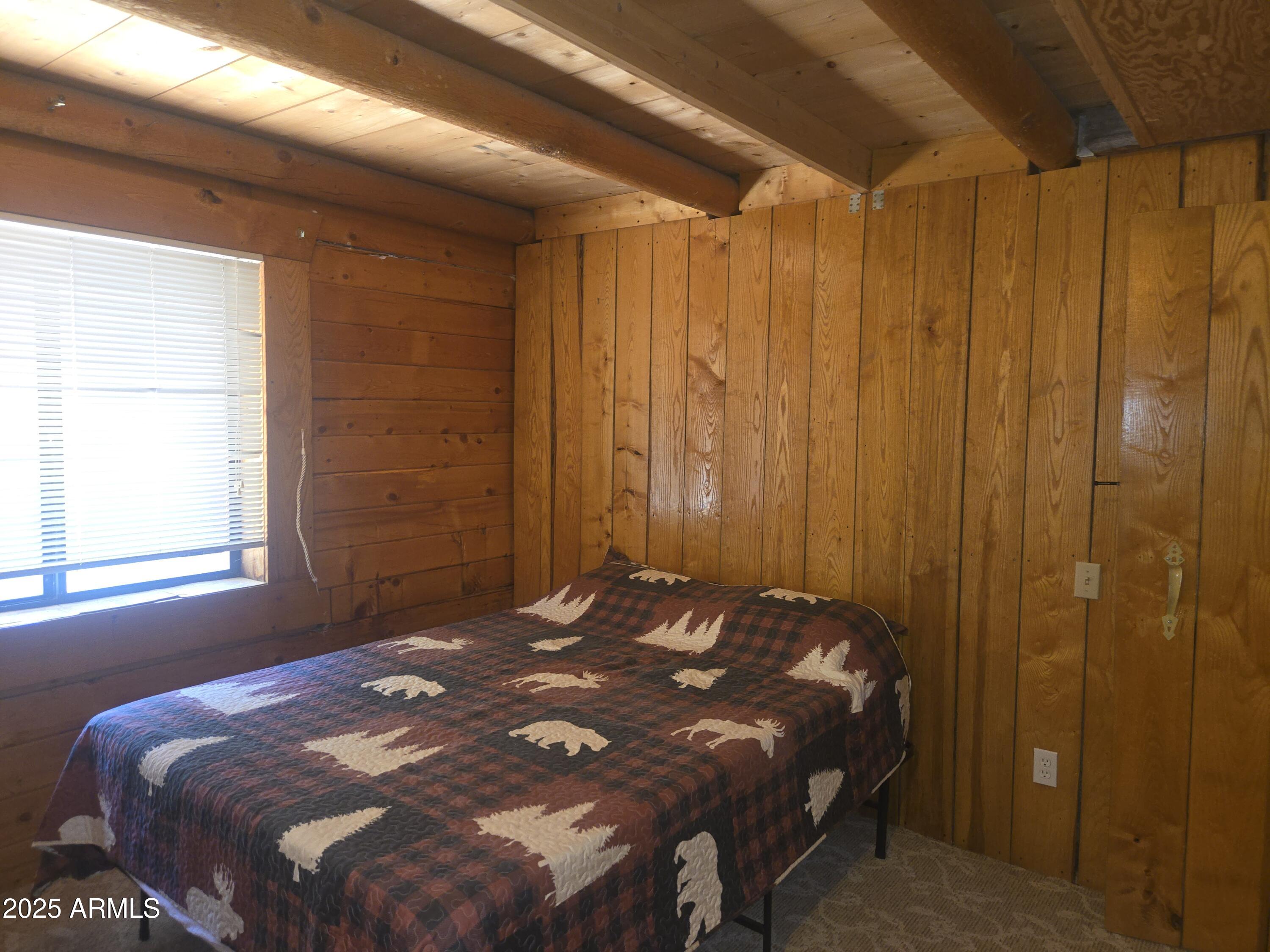 2145 Fishermans Road Overgaard, AZ 85933 - Photo 15 of 28 a bed sitting in a bedroom next to a window