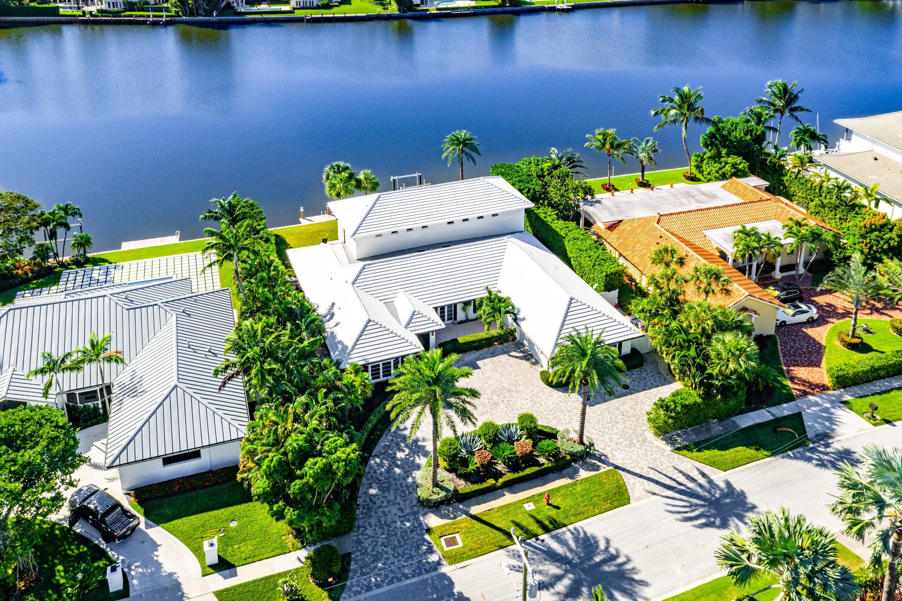 an aerial view of a house with a yard and lake view