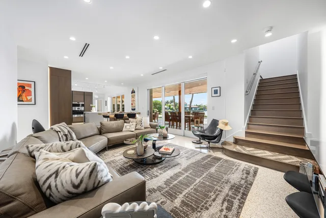 a living room with furniture kitchen view and a large window