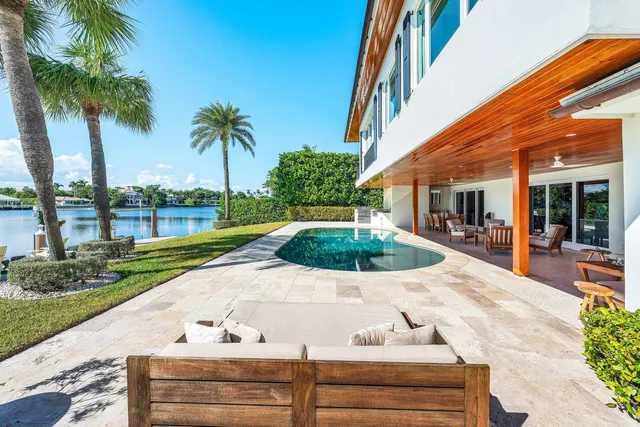 a view of yellow house with palm trees
