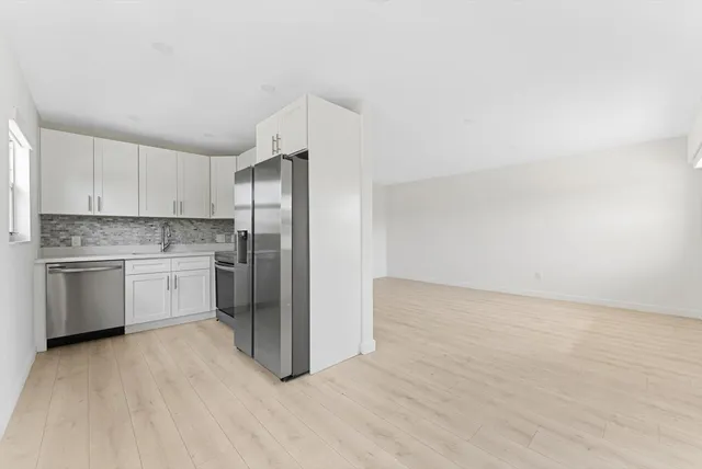 a kitchen with granite countertop white cabinets and stainless steel appliances