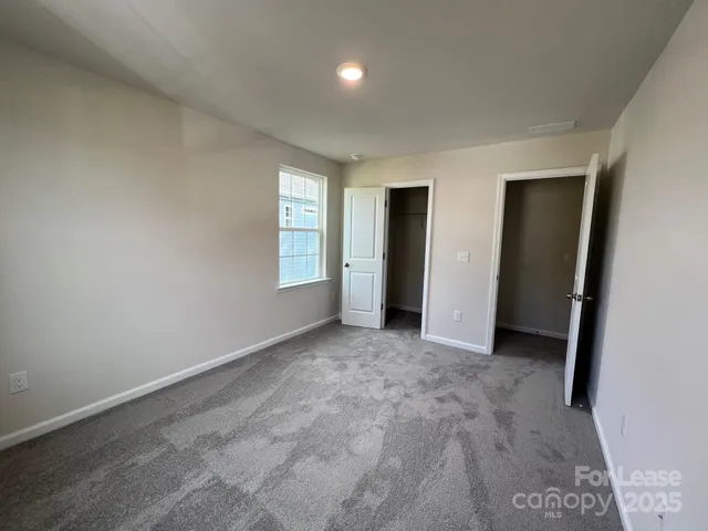 an empty room with closet and windows