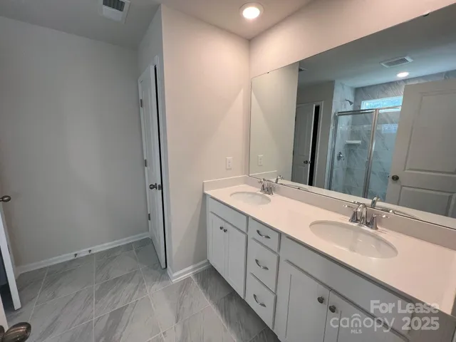 a bathroom with a double vanity sink and mirror
