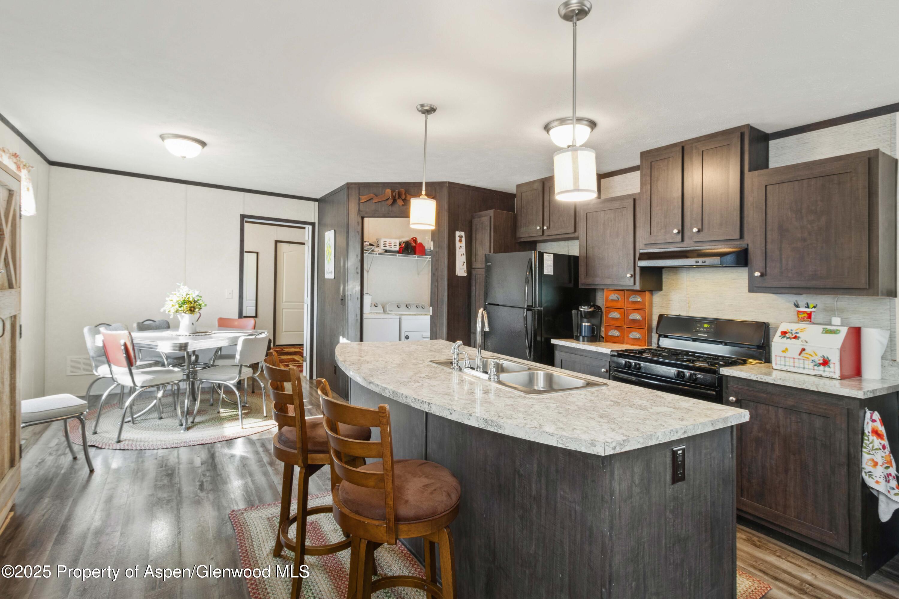 116 Iron Wedge Circle Parachute, CO 81635 - Photo 1 of 20 a kitchen with stainless steel appliances granite countertop a stove refrigerator a dining table and chairs with wooden floor