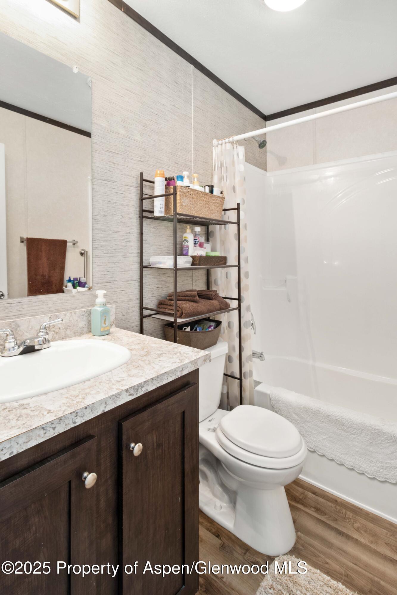 116 Iron Wedge Circle Parachute, CO 81635 - Photo 13 of 20 a bathroom with a granite countertop sink a toilet a mirror and bathtub