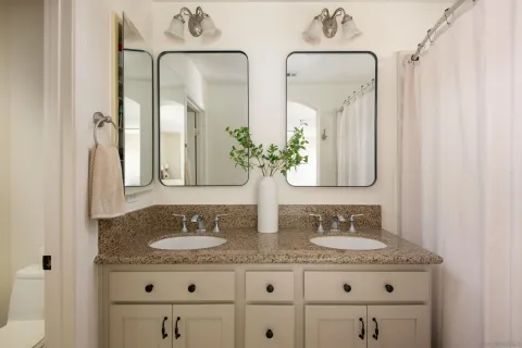 a bathroom with a granite countertop sink and a mirror