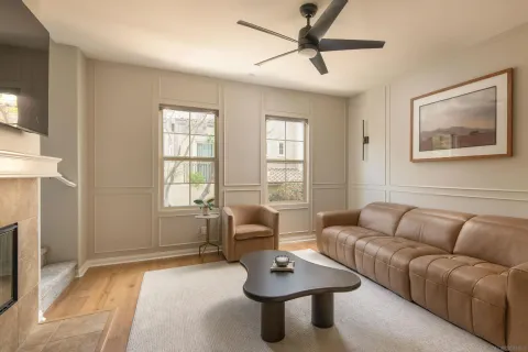 a living room with furniture a ceiling fan and a window