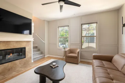 a living room with furniture a flat screen tv and a fireplace