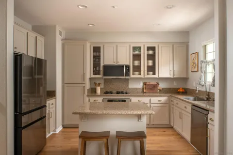 a kitchen with stainless steel appliances granite countertop a refrigerator stove microwave and sink