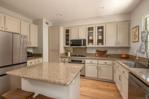 a kitchen with stainless steel appliances granite countertop a sink stove and refrigerator