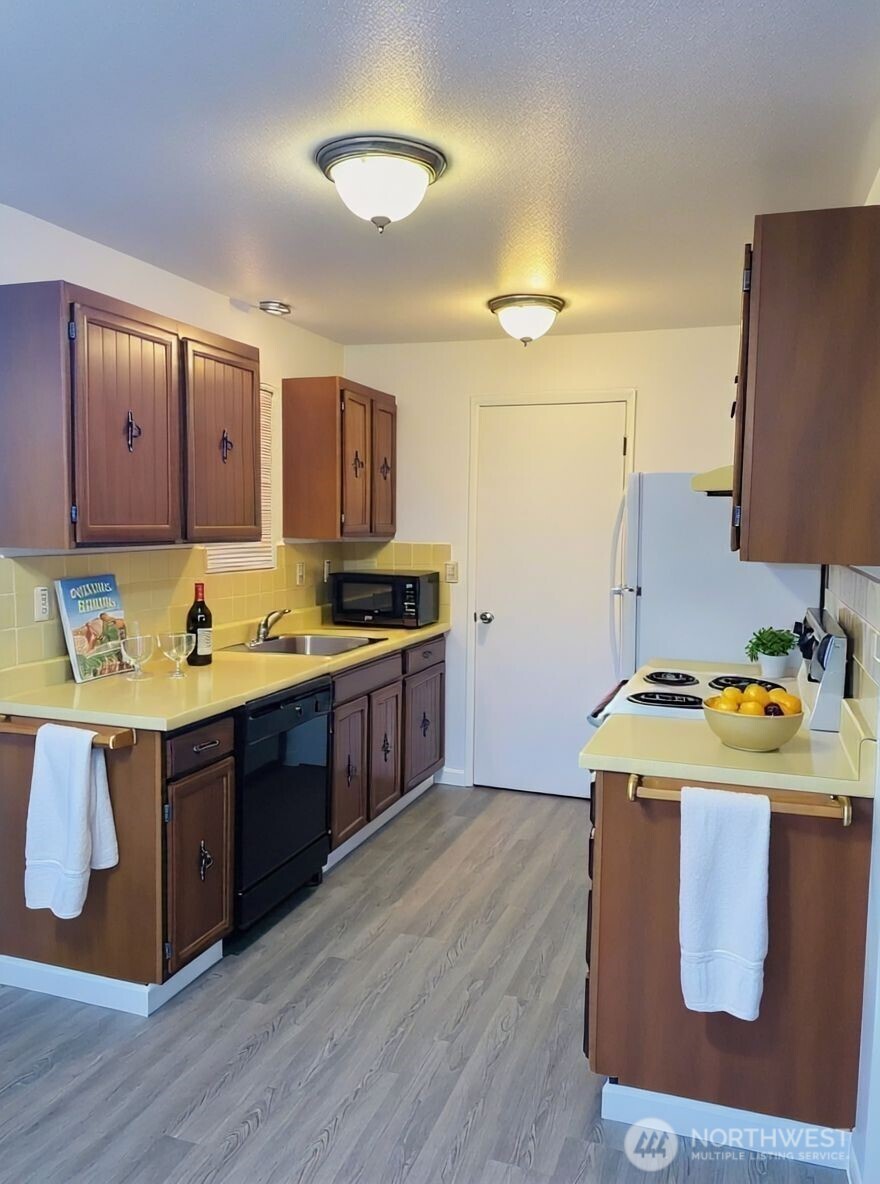 8848 Interlake Avenue North Seattle, WA 98103 - Photo 11 of 25 a kitchen with stainless steel appliances granite countertop a stove a sink and a refrigerator