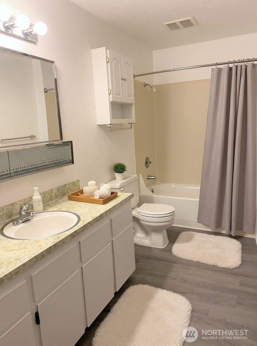 8848 Interlake Avenue North Seattle, WA 98103 - Photo 19 of 25 a bathroom with a sink a toilet and a mirror