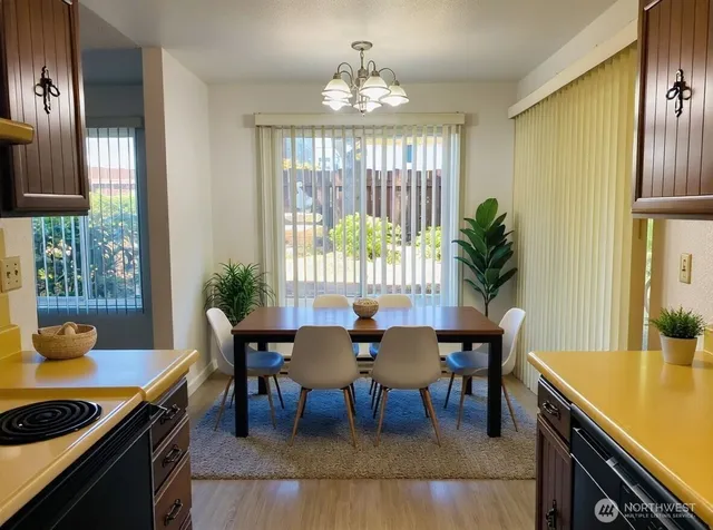 a dining room with furniture a chandelier and wooden floor