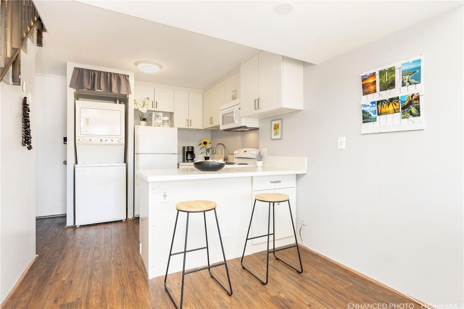 739 Hausten Street, Unit 901 Honolulu, HI 96826 - Photo 6 of 24 a kitchen with stainless steel appliances a refrigerator and wooden floor