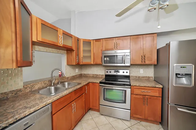 a kitchen with stainless steel appliances granite countertop a sink stove and refrigerator
