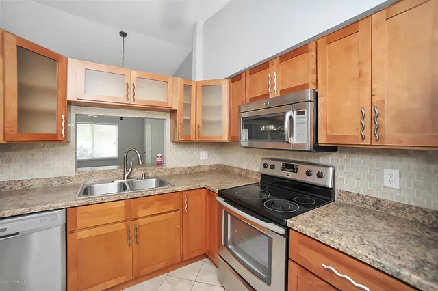 a kitchen with stainless steel appliances granite countertop a sink stove and microwave