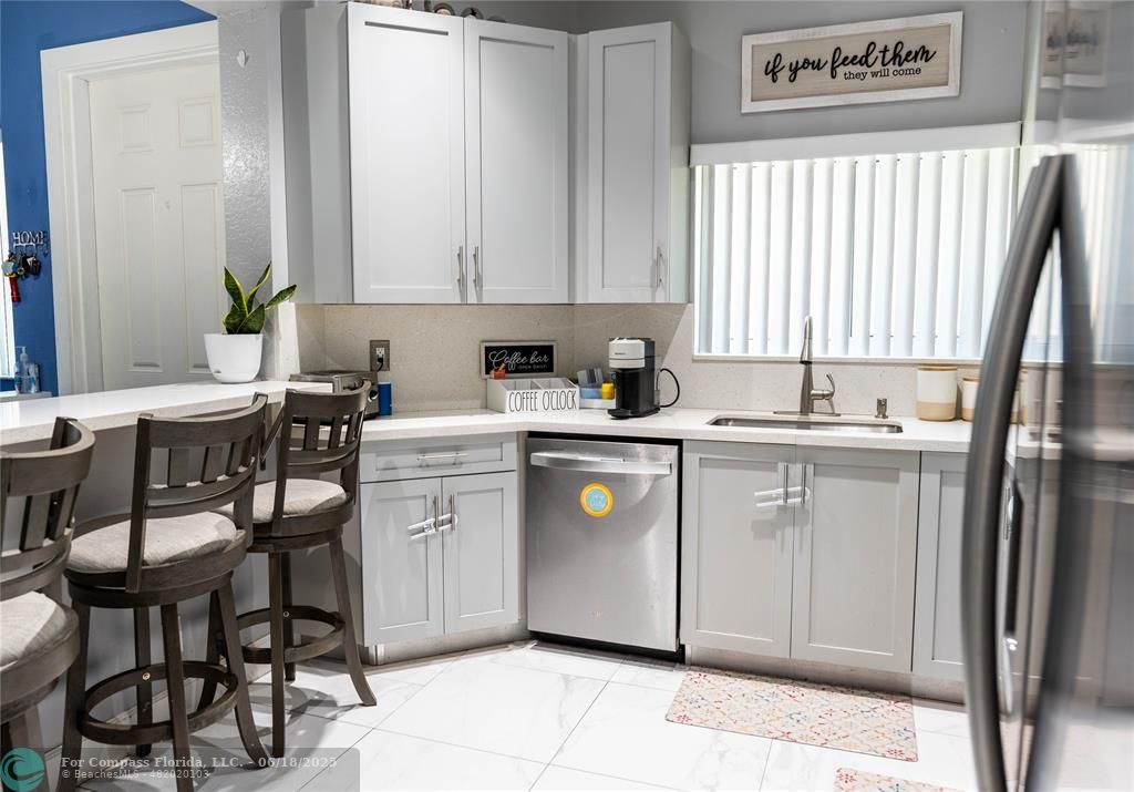 1102 Southwest 158th Avenue Pembroke Pines, FL 33027 - Photo 7 of 27 a kitchen that has a sink a table and chairs in it