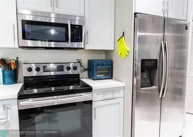 a kitchen with stainless steel appliances granite countertop a stove and a microwave