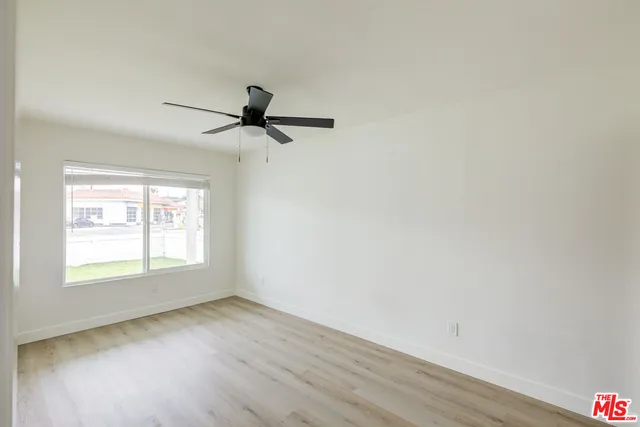 an empty room with a window and a ceiling fan