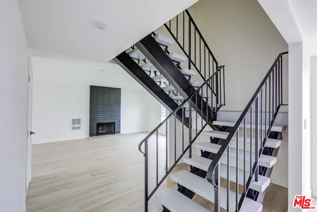 a view of staircase with wooden floor and white walls