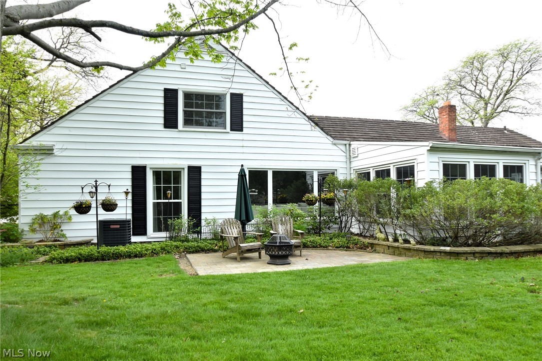 23901 Hazelmere Road Shaker Heights, OH 44122 - Photo 35 of 35 Back of property featuring a patio, a yard, a fire pit, and central air condition unit
