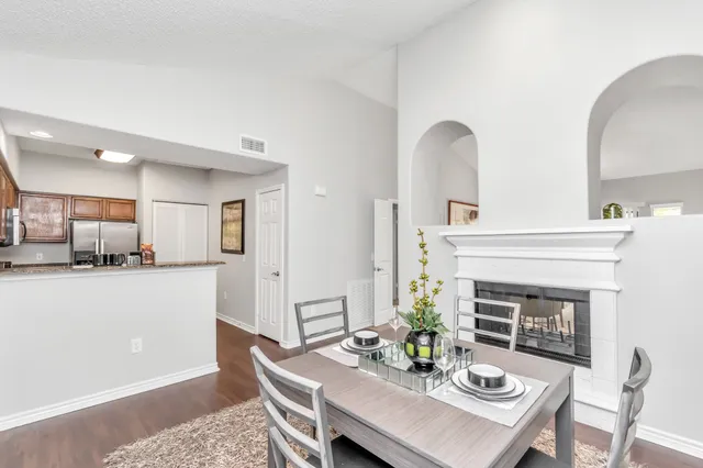 a living room with furniture a fireplace and dining table