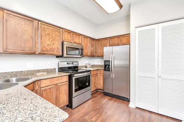a kitchen with granite countertop wooden cabinets stainless steel appliances and a window