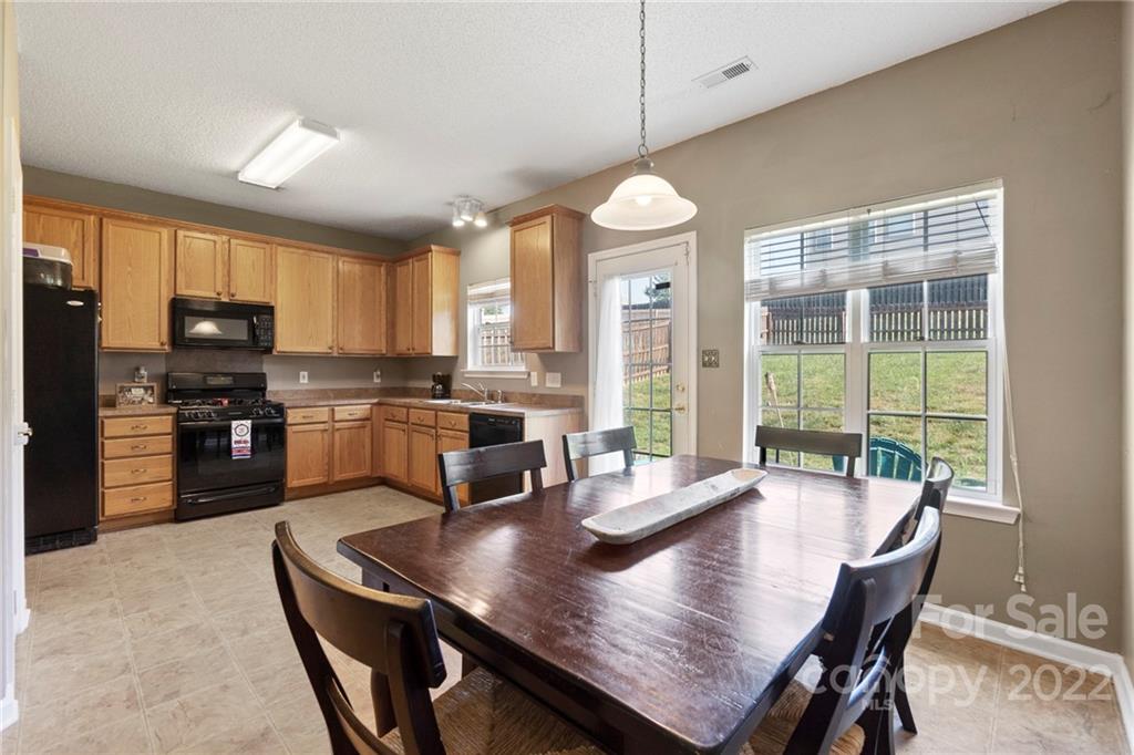 420 Wrayhill Drive Charlotte, NC 28262 - Photo 7 of 22 a kitchen with granite countertop a stove a sink a dining table and chairs