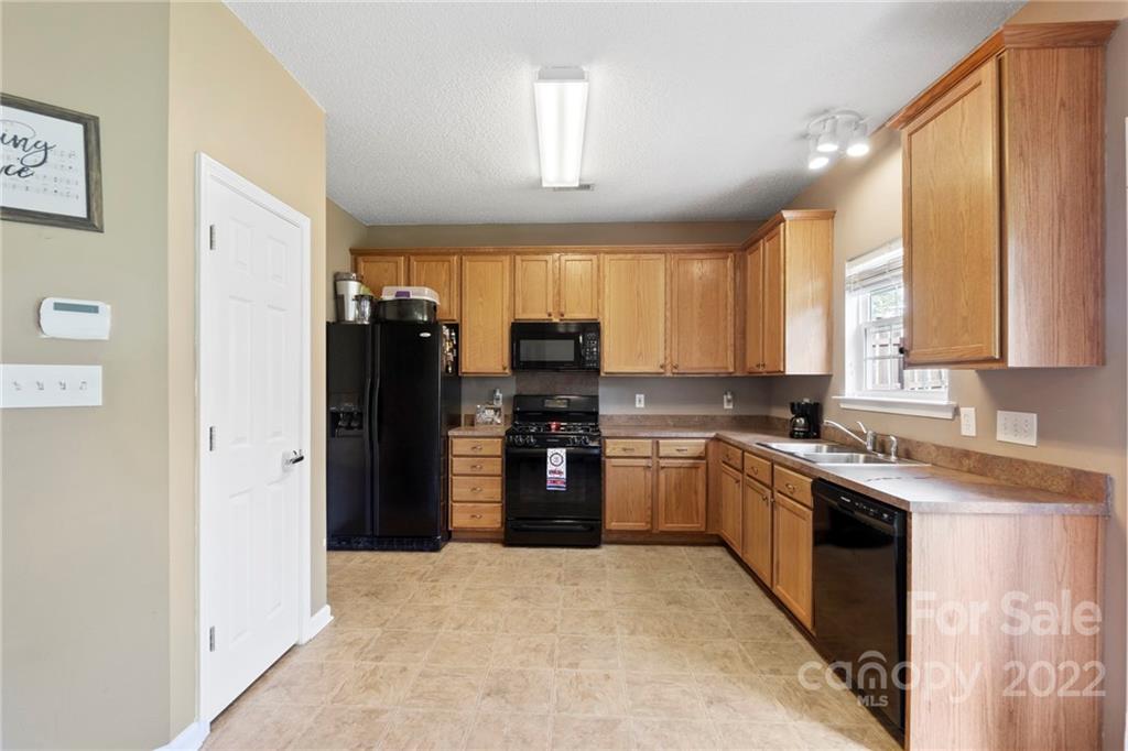 420 Wrayhill Drive Charlotte, NC 28262 - Photo 10 of 22 a kitchen with stainless steel appliances granite countertop a refrigerator a sink dishwasher a stove and a dining table with wooden cabinet