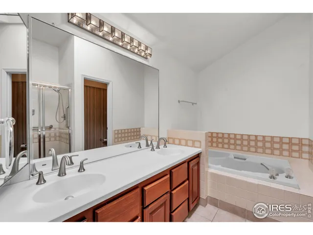 a bathroom with a sink double vanity granite tub and a mirror