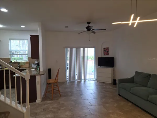 a living room with furniture a ceiling fan and a window