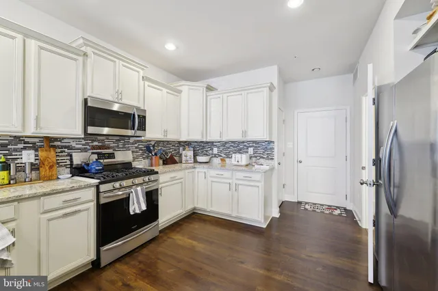 a kitchen with a refrigerator stove and white cabinets