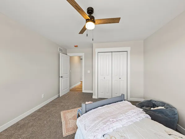 a bedroom with a bed and a chandelier fan
