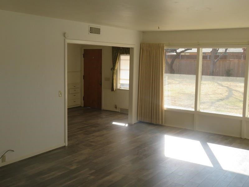 3405 37th Street Lubbock, TX 79413 - Photo 4 of 24 an empty room with wooden floor and windows