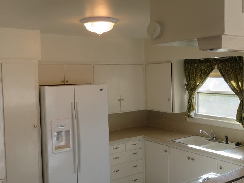 3405 37th Street Lubbock, TX 79413 - Photo 7 of 24 a kitchen with a refrigerator and window