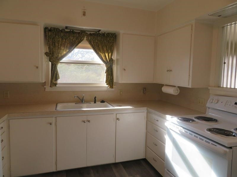 3405 37th Street Lubbock, TX 79413 - Photo 8 of 24 a kitchen with a sink a window and cabinets