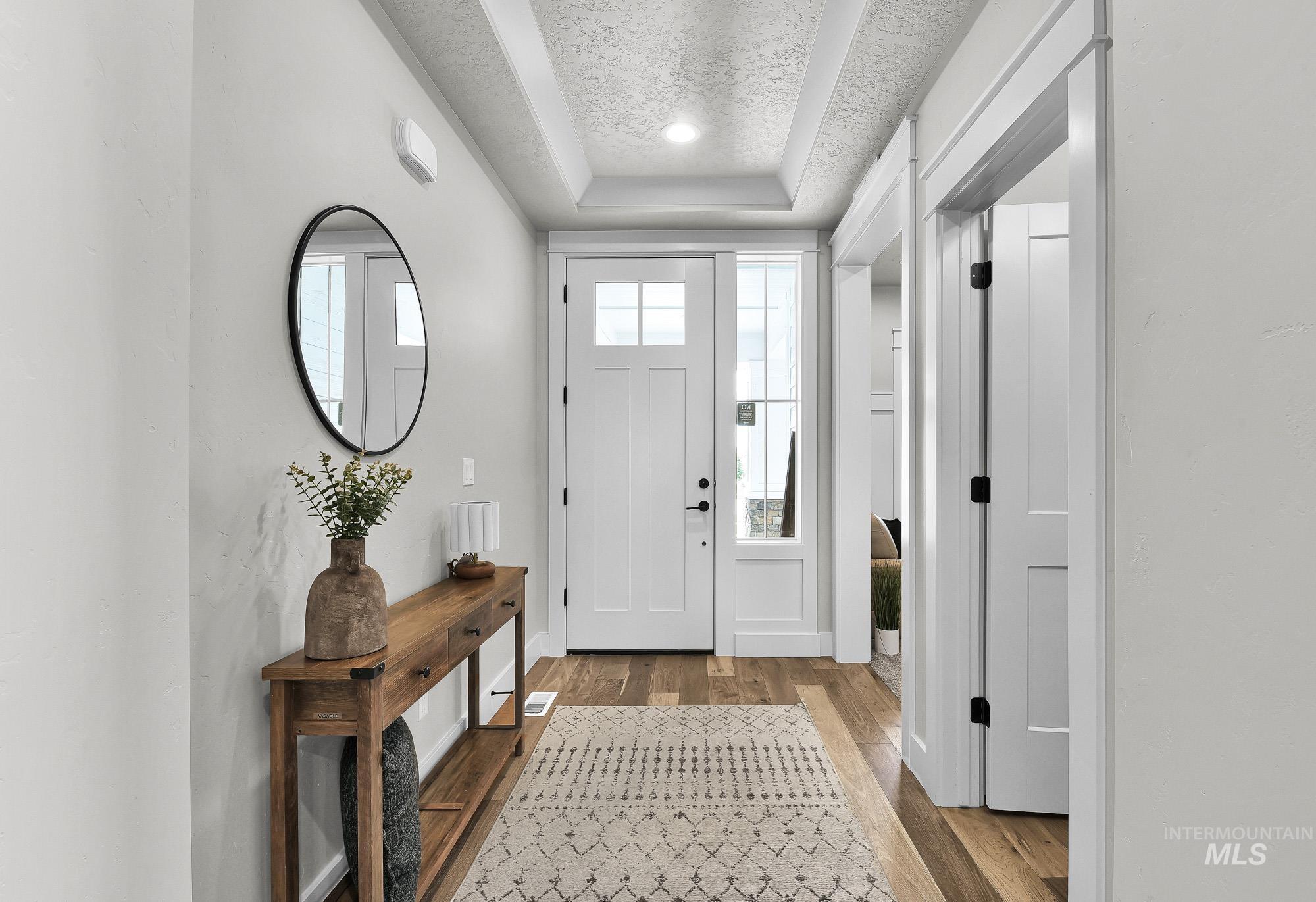 5676 East Zaffre Ridge Street Boise, ID 83716 - Photo 3 of 50 Entryway featuring wood-finish flooring, a white paneled entry door with sidelight, and a coffered ceiling with recessed lighting