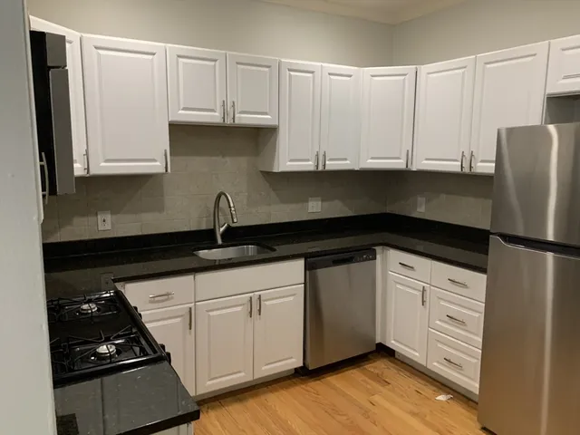 a kitchen with granite countertop white cabinets and white appliances