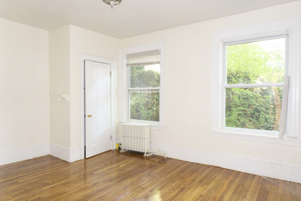 1789 Commonwealth Avenue, Unit 1 Boston, MA 02135 - Photo 6 of 11 a view of an empty room with wooden floor and a window