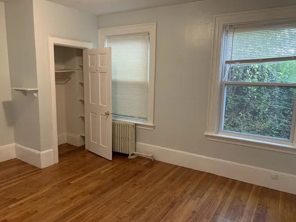 an empty room with wooden floor and a window