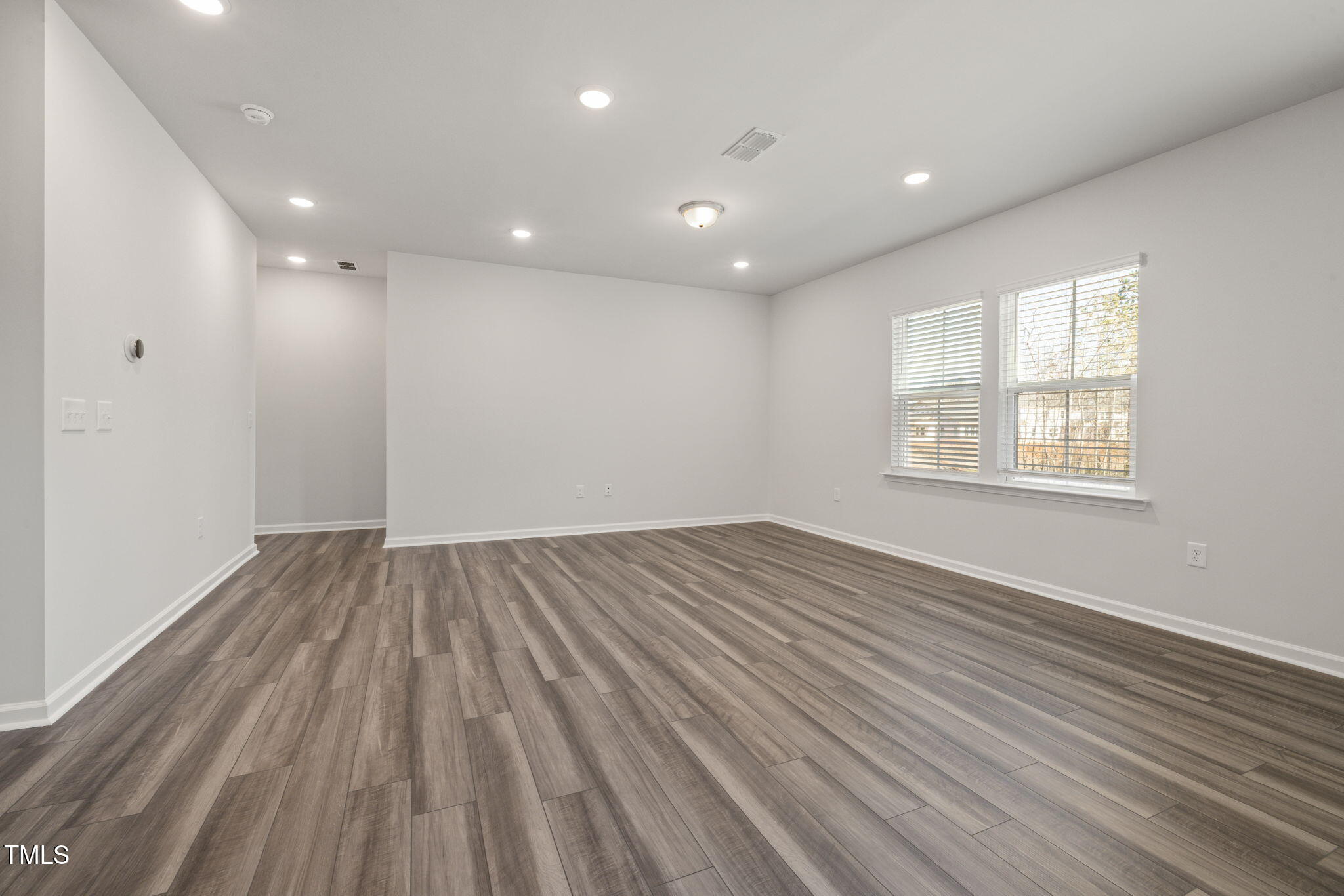 712 Ben Ledi Court Raleigh, NC 27603 - Photo 7 of 21 an empty room with wooden floor and windows