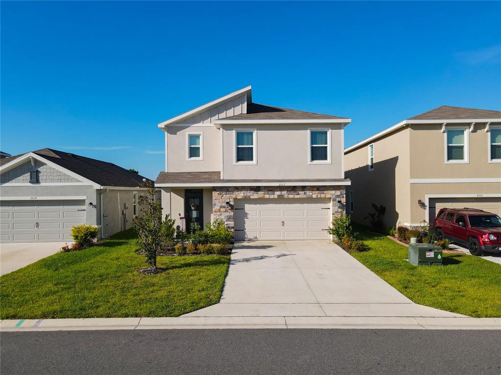 a front view of a house with a yard and garage